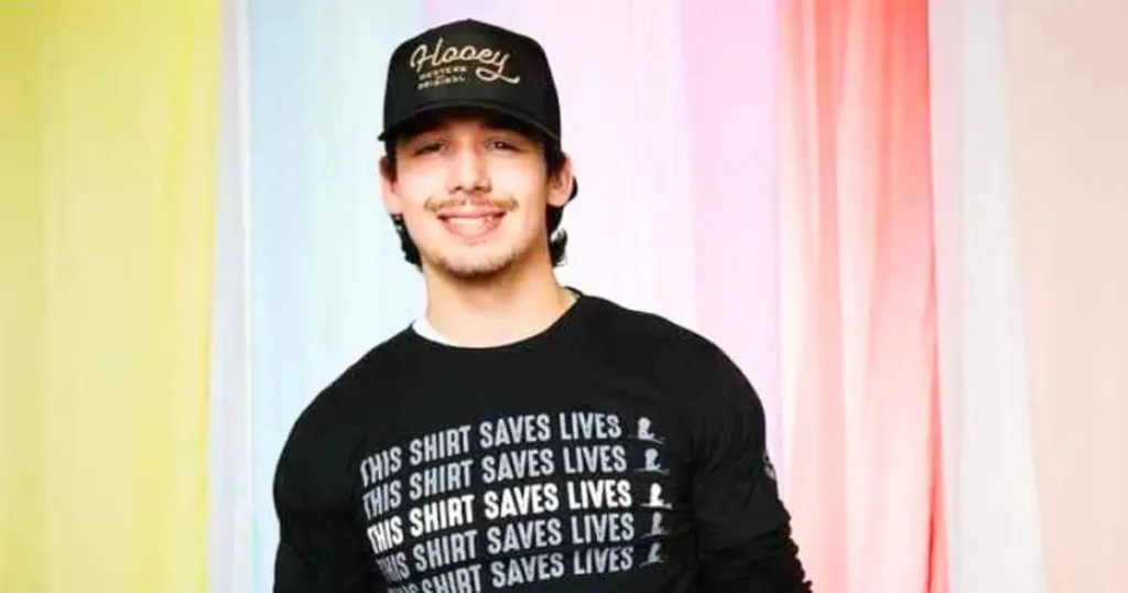 Noah Thompson wearing a hat and a shirt that reads "I love you," showcasing a heartfelt expression of affection.
